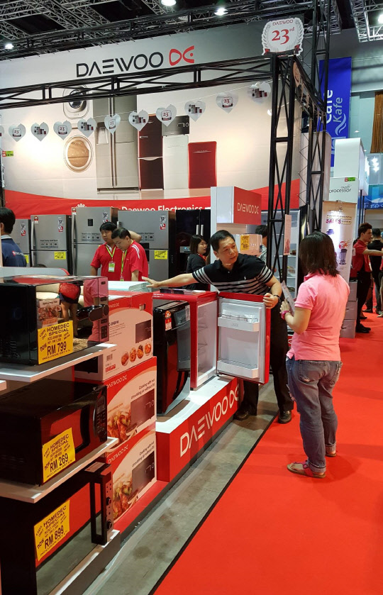 동부대우전자 직원이 말레이시아에서 열린 홈덱2016 박람회 전시관에서 현지 소비자에게 복고풍 디자인 '더 클래식' 냉장고 제품을 설명하고 있다. <동부대우전자 제공>